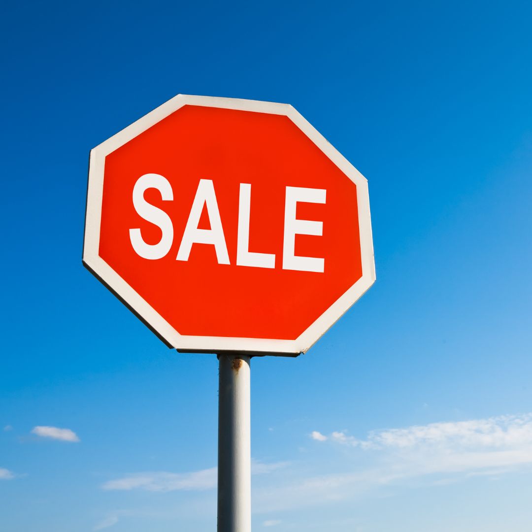 Red 'SALE' sign against a blue sky